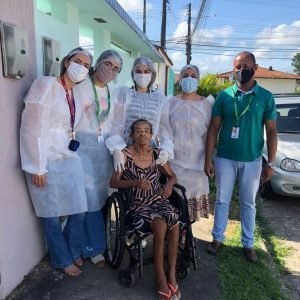 A paciente Maria José Freitas: a fisioterapeuta, Suelânea Brandão; a nutricionista, Anny Mendonça; a acadêmica de Nutrição, Patrícia Melo, o motorista do PADI, Juciran dos Santos e a terapeuta ocupacional, Thaís Fortes
