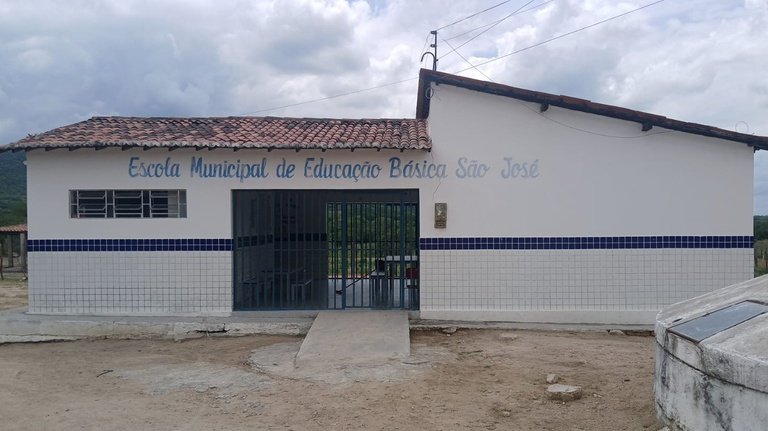 Fachada da Escola Municipal de Educação Básica São José, prédio branco com detalhes em azulejos azuis e teto de telha.