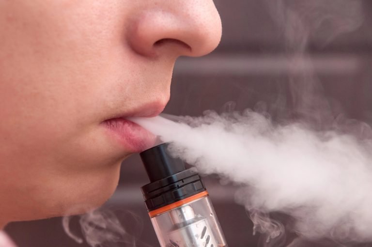 Adolescente fumando cigarro eletrônico